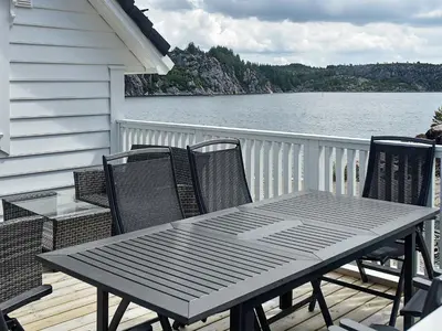 a table and chairs on a deck with a view of the water at 8 person holiday home in Urangsvåg-By Traum in Ervik