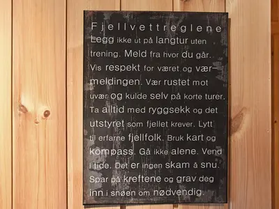 a sign on a wooden wall with a sign on it at 6 person holiday home in Rennebu-By Traum in Sundset