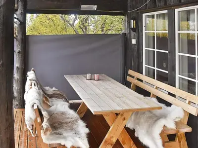 a wooden table and benches on a porch with a table and chairs at 6 person holiday home in Rennebu-By Traum in Sundset