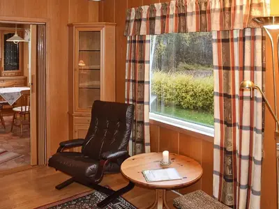 a room with a chair and a table and a window at 8 person holiday home in VÅGLAND-By Traum in Vågland