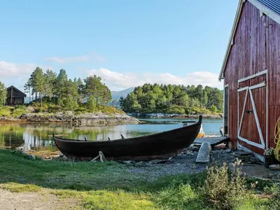 a boat sitting on the ground next to a barn at 8 person holiday home in VÅGLAND-By Traum in Vågland