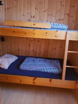 a bunk bed in a cabin with a blue mattress at Solstua Three-bedroom Cottage in Geilo