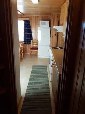 a kitchen with a refrigerator and a kitchen rug at Solstua Three-bedroom Cottage in Geilo