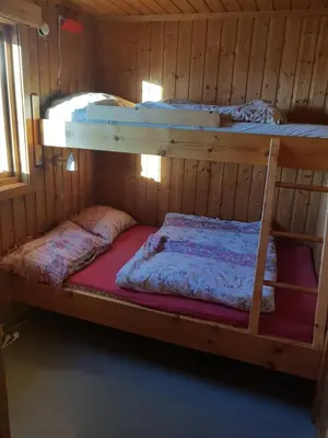 two bunk beds in a wooden room with at Nybu Two-bedroom cottage in Geilo