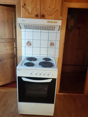 a white stove top oven sitting inside of a kitchen at Nybu Two-bedroom cottage in Geilo