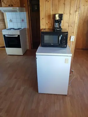 a kitchen with a microwave on top of a refrigerator at Nybu Two-bedroom cottage in Geilo