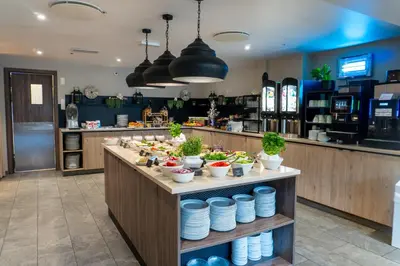 a buffet line in a restaurant with bowls and plates at Førde Hotel - Unike Hoteller in Førde