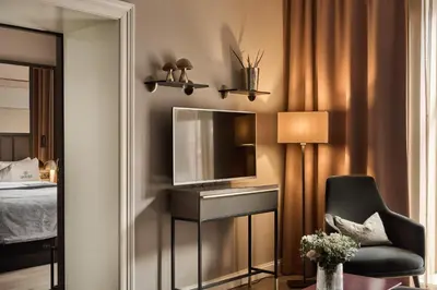 a bedroom with a tv and a chair and a mirror at Opus 16, a Member of Small Luxury Hotels in Bergen