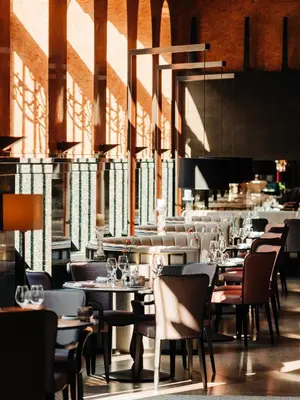 a dining room with tables and chairs and sunlight at Opus 16, a Member of Small Luxury Hotels in Bergen