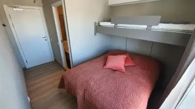 a small bedroom with a pink pillow on a bed at Hovden Fjellstoge in Hovden