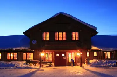 a building with lights on in the snow at Hovden Fjellstoge in Hovden