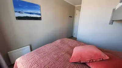 a bedroom with a bed with a pink pillow at Hovden Fjellstoge in Hovden