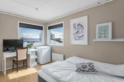 a bedroom with a bed and a desk with a computer at Brekstad Gjestehus AS in Brekstad
