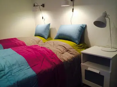 a bedroom with two beds with colorful sheets and a lamp at Brekstad Gjestehus AS in Brekstad