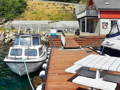 a boat is docked at a dock in the water at 4 person holiday home in Urangsvåg-By Traum in Ervik