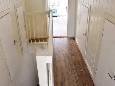 a hallway with a white door and a wooden floor at 8 person holiday home in Urangsvåg-By Traum in Ervik