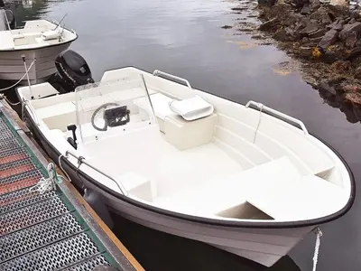 a white boat tied to a dock in the water at 5 person holiday home in Selje-By Traum in Selje