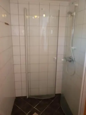 a shower in a white tiled bathroom at Knutebu Two-Bedroom Cottage in Geilo