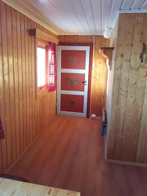 a hallway with a red door and wooden walls at Knutebu Two-Bedroom Cottage in Geilo