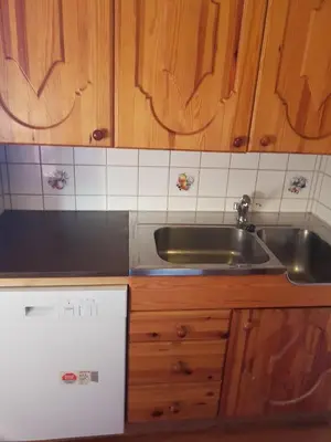a kitchen with a stainless steel sink and wooden cabinets at Knutebu Two-Bedroom Cottage in Geilo
