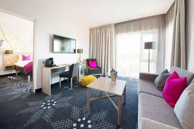 a living room with a couch and a desk at Thon Hotel Elgstua in Elverum