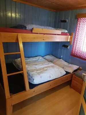 two bunk beds in a room with blue walls at Fjellbu Two-bedroom Cottage in Geilo