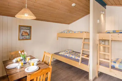 a dining room with a table and a bunk bed at Flåm Hostel & Cabins in Flåm