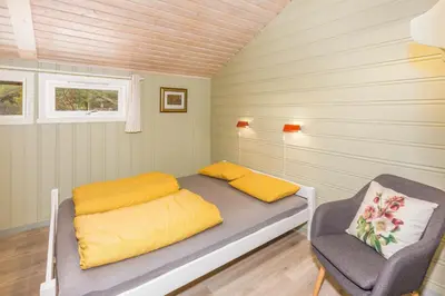 a small bedroom with a bed and a chair at Flåm Hostel & Cabins in Flåm