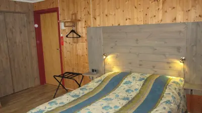a bedroom with a large bed with a wooden wall at Høvringen Fjellstue in Høvringen