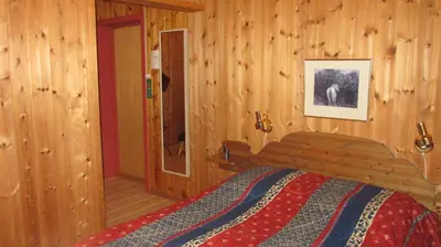 a bedroom with a bed in a wooden room at Høvringen Fjellstue in Høvringen