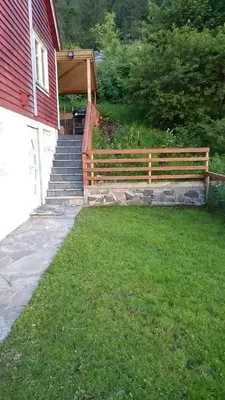 a wooden fence next to a house with a staircase at Bazyl Apartment in Folkedal