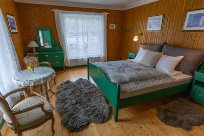a bedroom with a bed and a table and a chair at Bygdin Høyfjellshotell in Beitostøl