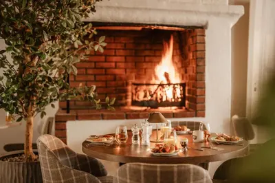 a table with plates of food in front of a fireplace at Jegtvolden Fjordhotell in Straumen