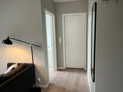 a living room with a couch and a lamp at Kong Oscars Apartments in Bergen