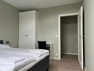 a bedroom with a bed and a desk with a chair at Kong Oscars Apartments in Bergen