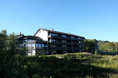 a building on top of a grassy hill at Fjelltun Fritidsleiligheter, leilighet 407 in Geilo