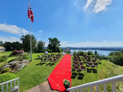 a wedding ceremony with chairs and a red carpet at Westland Hotel in Lindås