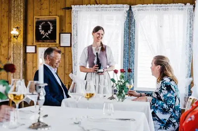 a woman standing in front of a table with people at Utne Hotel in Utne