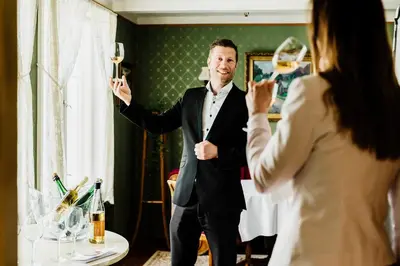 a woman taking a picture of a man holding champagne glasses at Utne Hotel in Utne