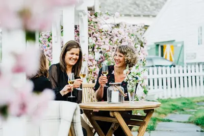 two women sitting at a table with glasses of wine at Utne Hotel in Utne
