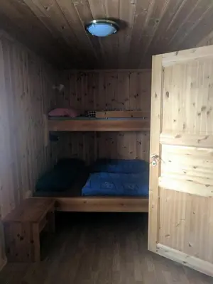 a bunk bed in a wooden room with a door at Granbu in Geilo