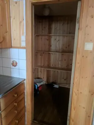 a kitchen with wooden walls and a door into a room at Granbu in Geilo