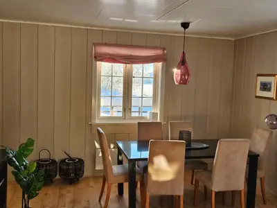 a dining room with a table and chairs and a window at Voss Interlake in Skulestadmo