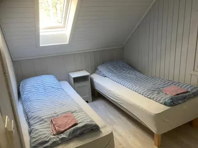 two beds in a small room with a window at Voss Interlake in Skulestadmo