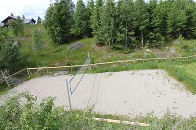 a sand volleyball court in the middle of a field at Luxury Mountain Villa in Strandlykkja
