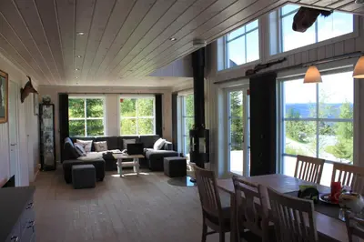 a living room filled with furniture and windows at Luxury Mountain Villa in Strandlykkja