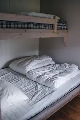 an unmade bed in a room with two bunk beds at Hovdehytta in Hovden