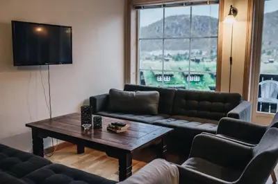 a living room with couches and a table and a television at Hovdehytta in Hovden