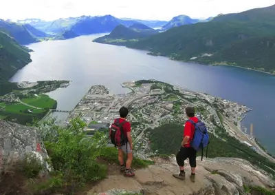 two men standing on top of a mountain overlooking a lake at Grand Hotel - by Classic Norway Hotels in Åndalsnes