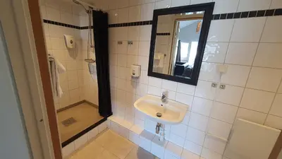 a bathroom with a sink and a mirror at Systra Hotel Apartments Sjøholt in Sjøholt